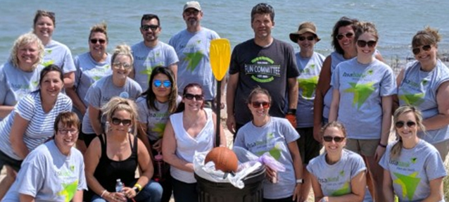 a group of volunteers standing outside in front of a body of water