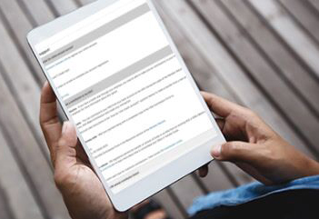 Male hands holding tablet with FAQs on screen.