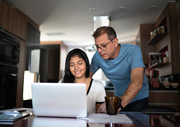 Father and daughter looking at a laptop