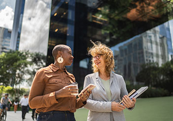 Two women walking outside an office building