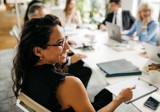 Woman in a meeting looking over her shoulder