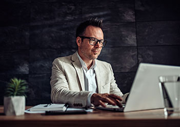 Man sitting at his desk, working on a computer